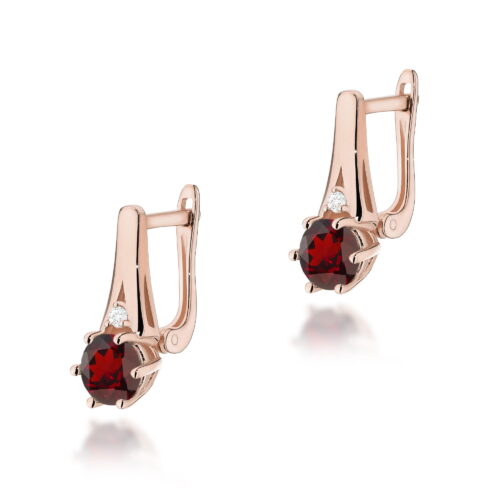 Złote kolczyki z czerwonymi kamieniami i małymi diamentami, eleganckie i stylowe.
