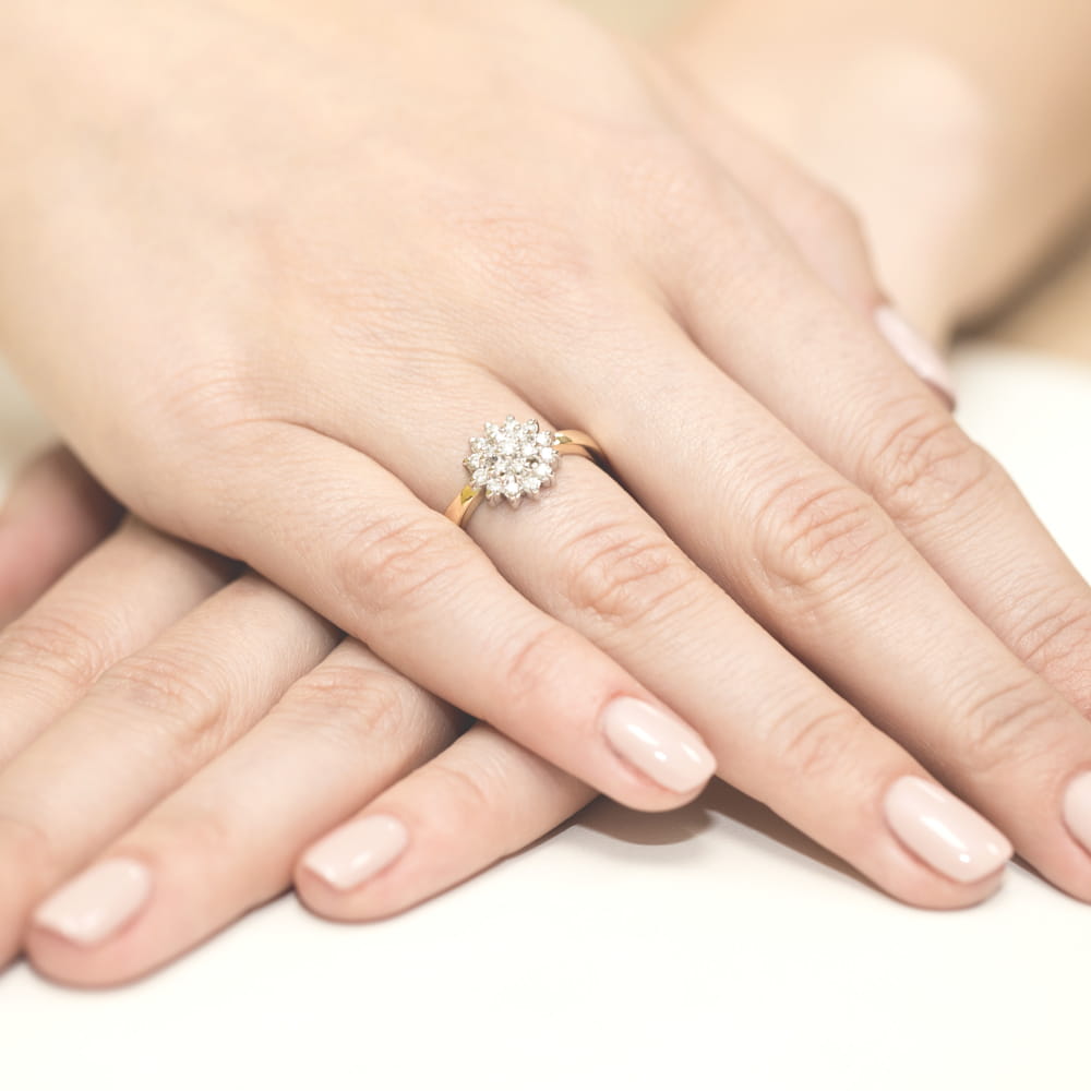 W0004.Z3.DIW.01_4 Złoty pierścionek z diamentowym oczkiem na dłoniach z zadbanymi paznokciami.