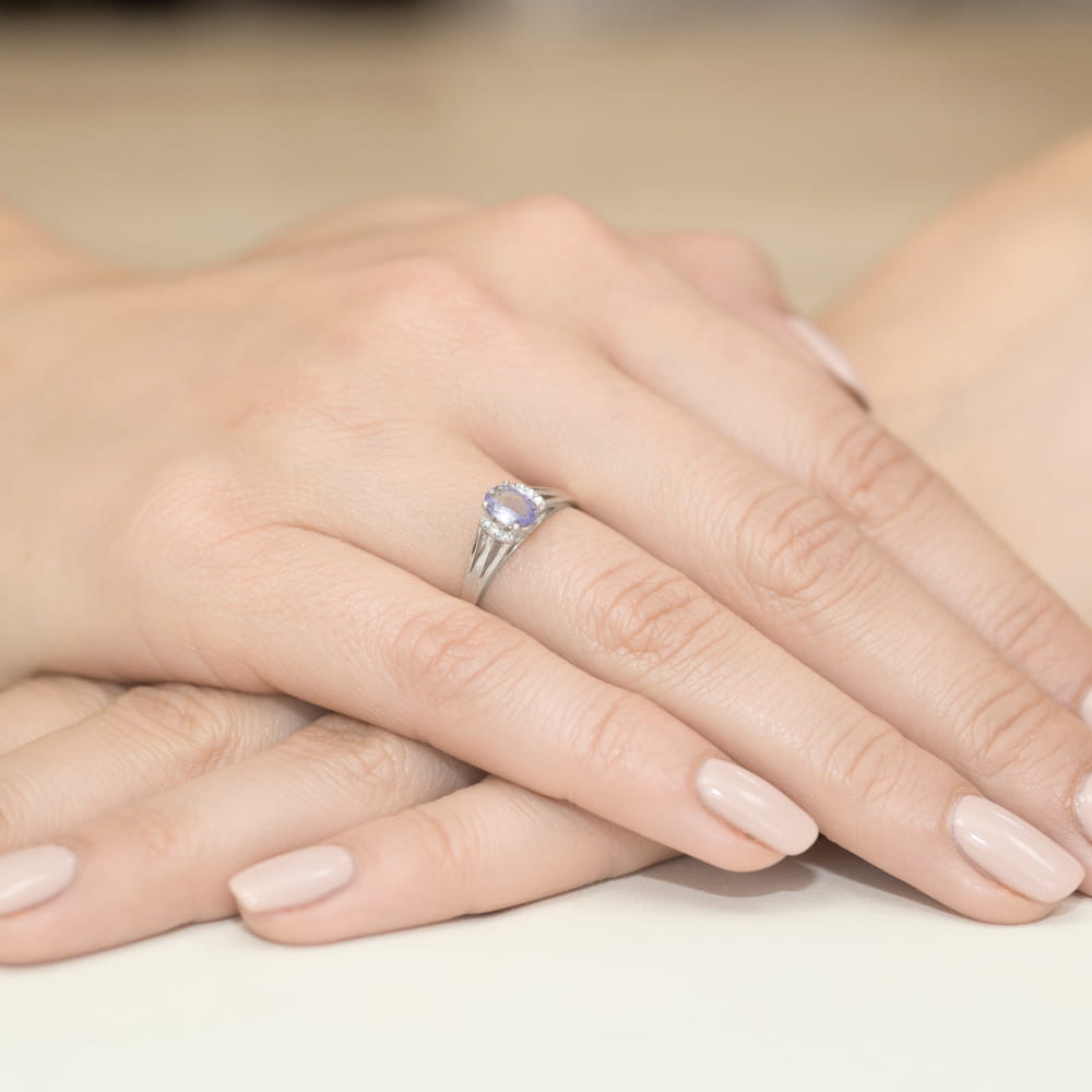 W0005.B3.TAP.01_4 Dwie ręce z delikatnym pierścionkiem na palcu, o jasnym kolorze paznokci.