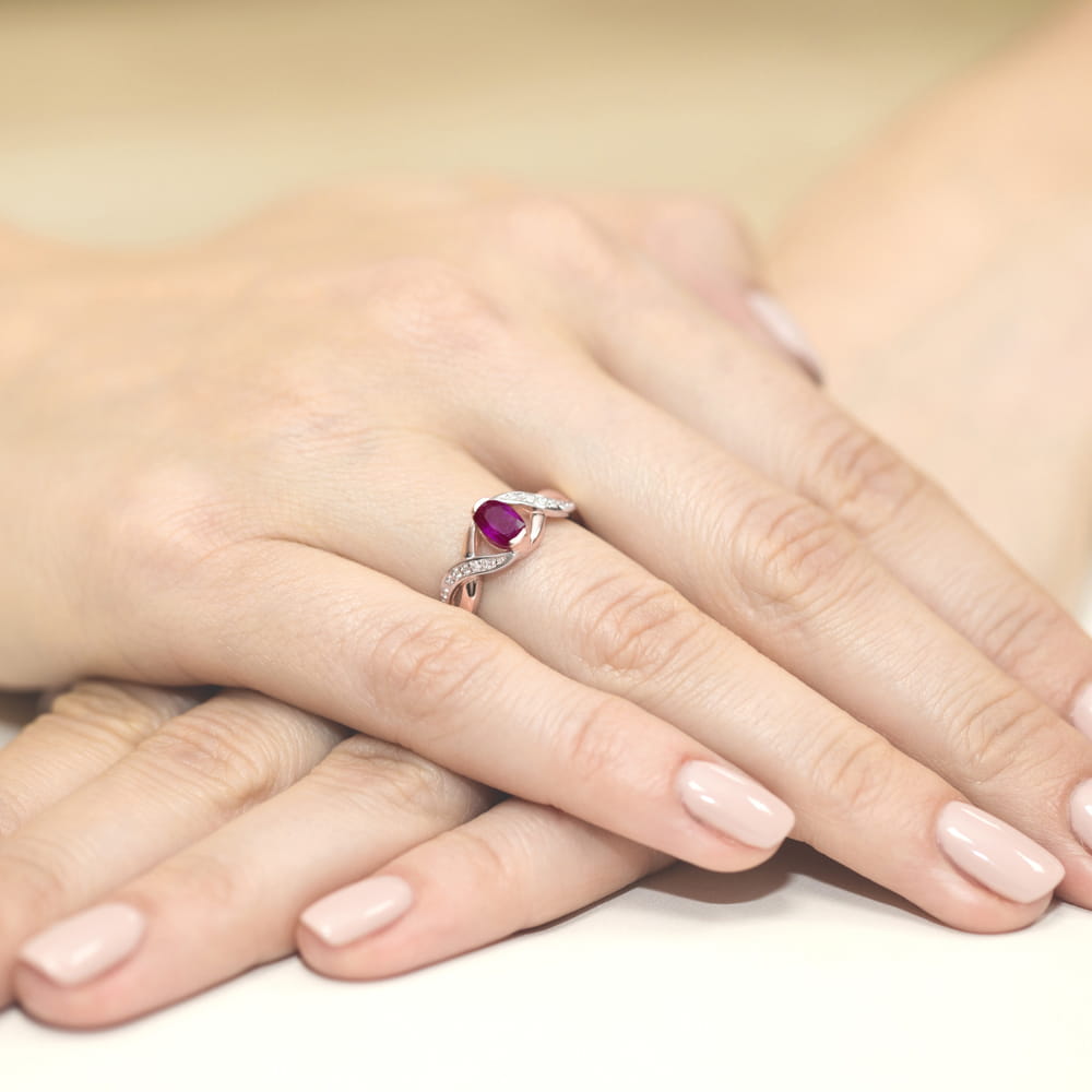W0028.R3.RHR.01_4 Pierścionek z rubinem i diamentami na palcu, dłonie z delikatnym manicure w jasnym kolorze.