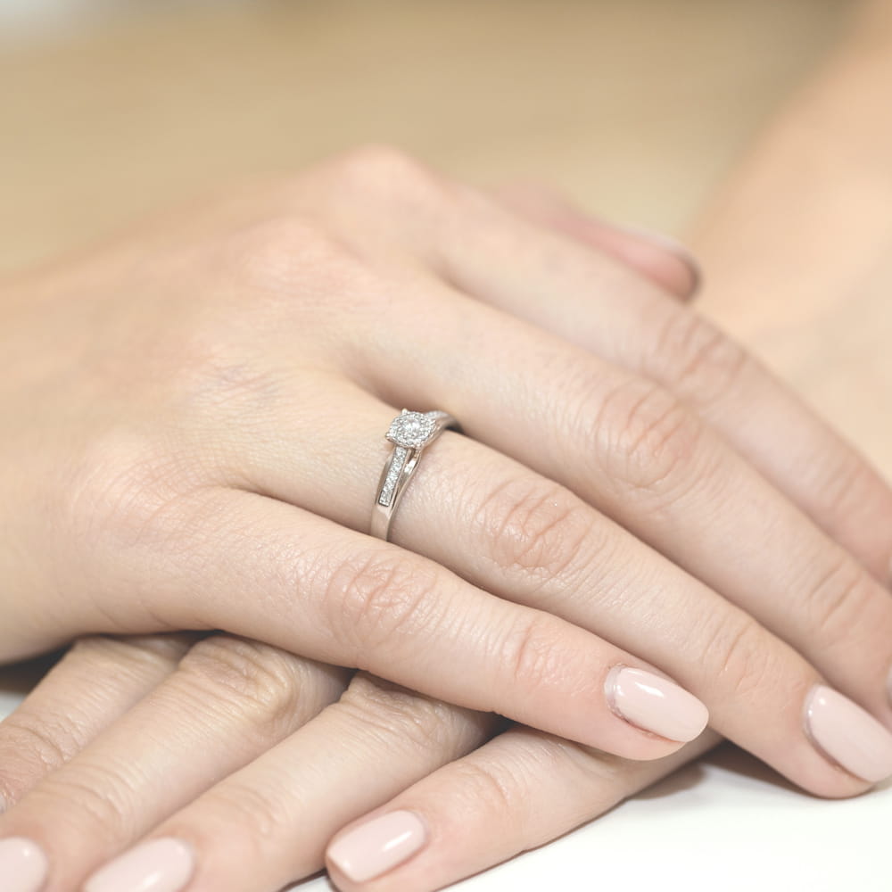 W0034.B3.DIW.01_4 Dwie dłonie z delikatnym pierścionkiem zaręczynowym na jednym z palców, z subtelnym manicure.