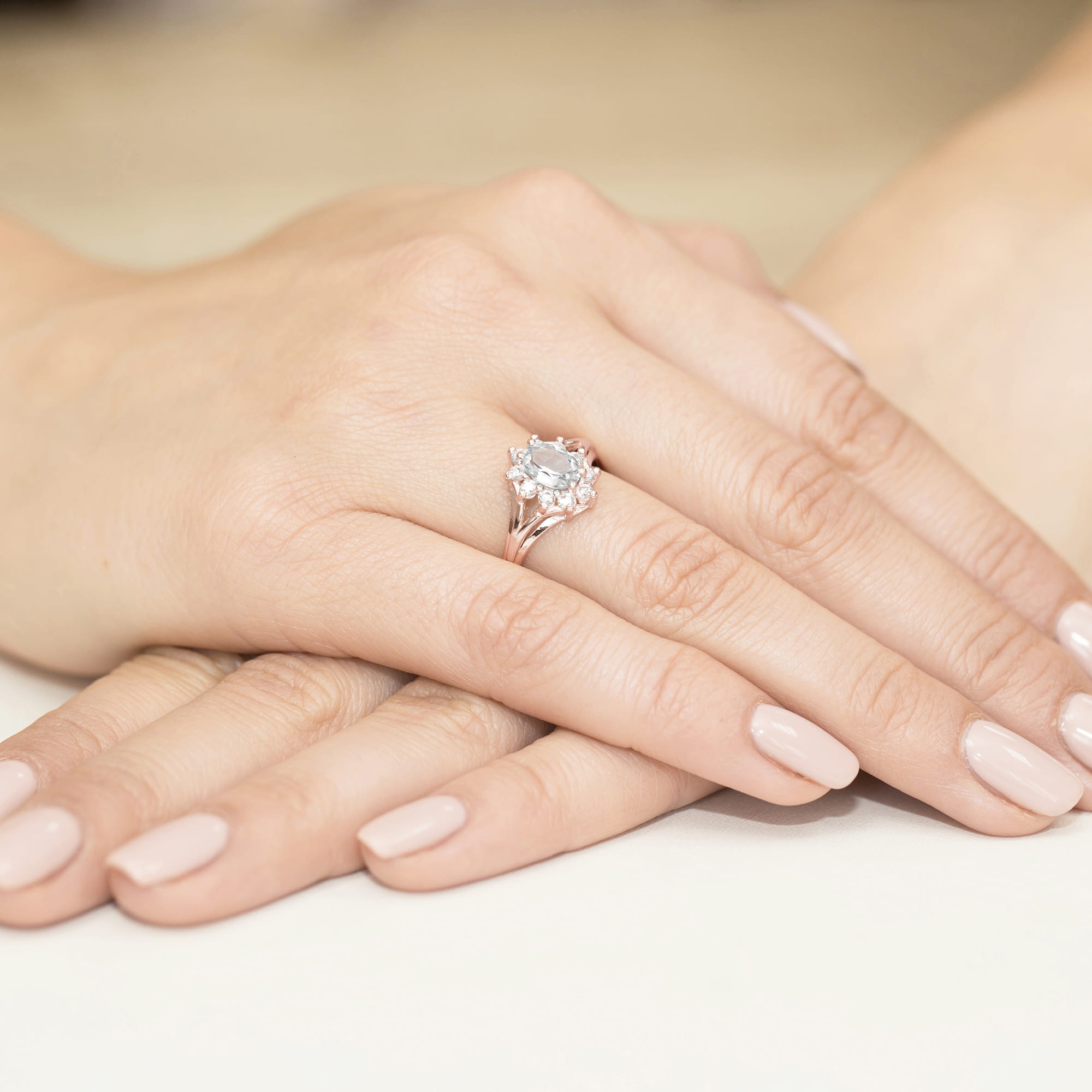 W0037.R3.LDW.01_4 Na dłoni z delikatnym manicure znajduje się pierścionek z dużym, błyszczącym kamieniem.