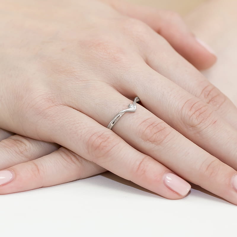 W0051.B3.DIW.01_4 Srebrny pierścionek z diamentem na palcu, dłonie z delikatnym manicure.