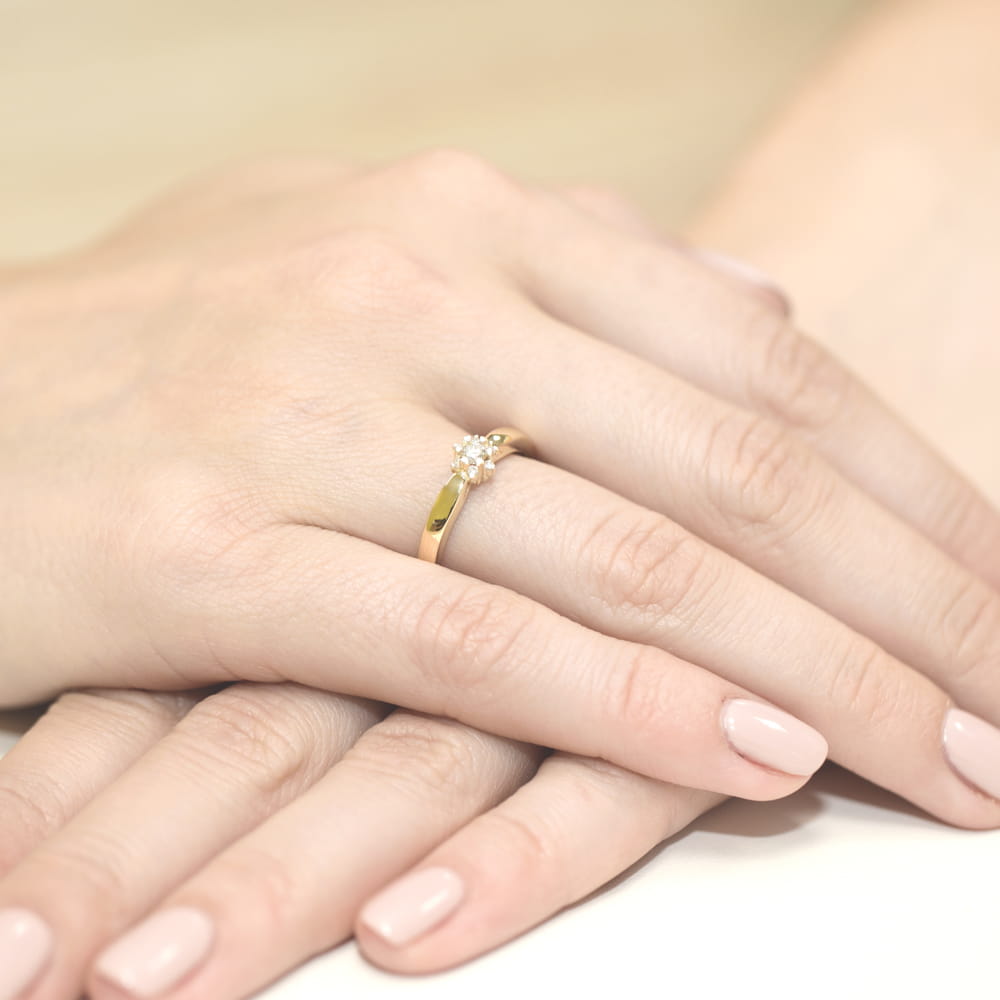 W0061.Z3.DIW.01_4 Złoty pierścionek z diamentem na palcu kobiety, ręce z delikatnym manicure.
