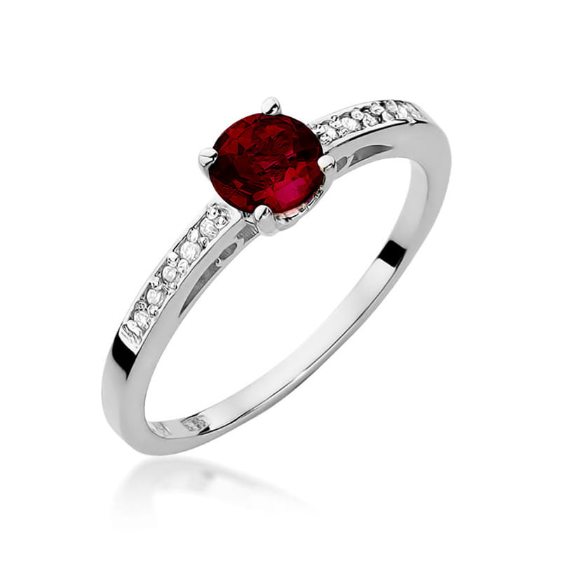 W0066.B3.GAR.01_1 Srebrny pierścionek z okrągłym, czerwonym kamieniem i drobnymi, błyszczącymi diamentami po bokach.