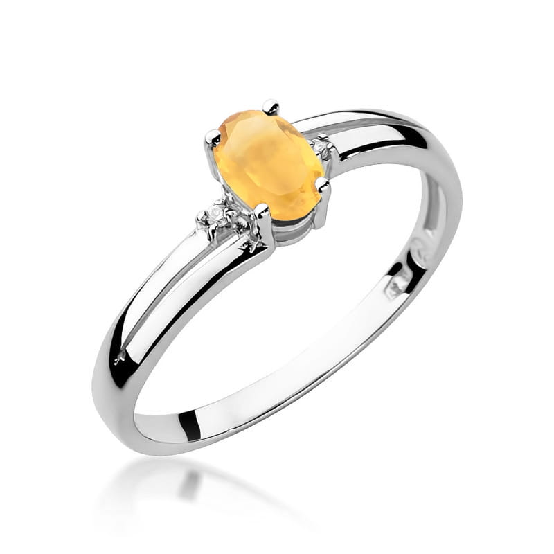 W0068.B3.CIY.01_1 Srebrny pierścionek z owalnym, żółtym kamieniem i dwoma małymi diamentami po bokach.