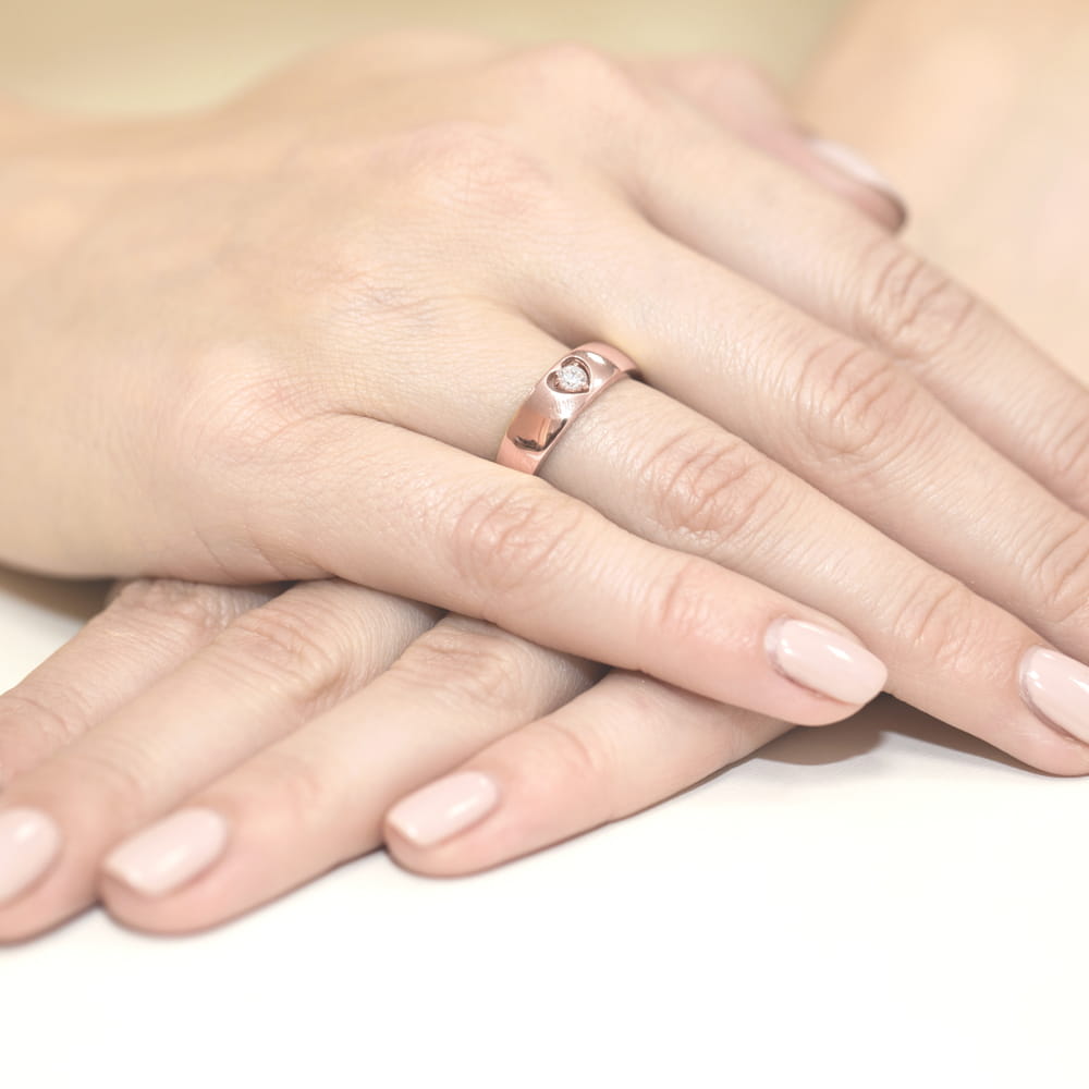 W0071.R3.DIW.01_4 Dwie ręce z delikatnym manicure, jedna z pierścionkiem z kamieniem na palcu.