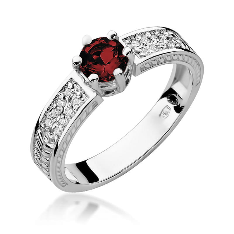 W0075.B3.RUR.01_1 Srebrny pierścionek z czerwonym kamieniem w centralnej części i błyszczącymi diamentami po bokach.