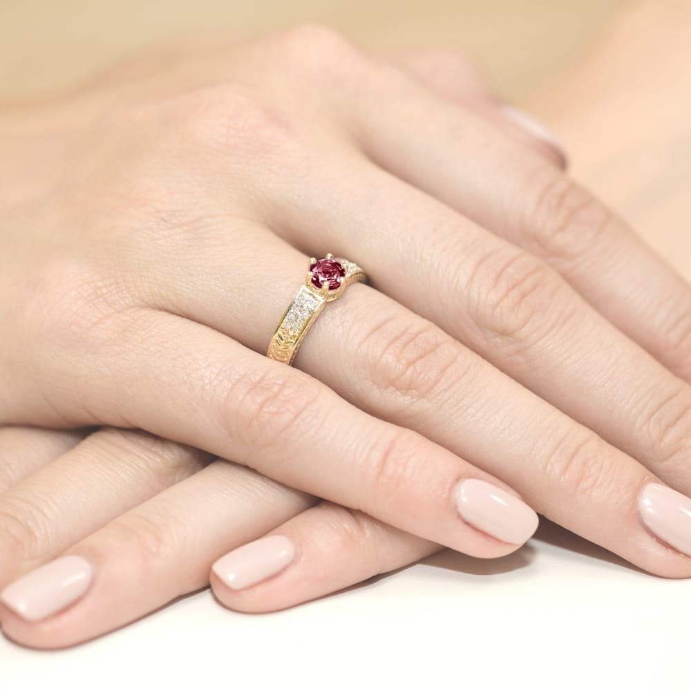 W0075.Z3.RUR.01_4 Złoty pierścionek z rubinem i diamentami na dłoniach z zadbanymi paznokciami.