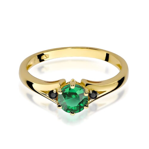 Złoty pierścionek z okrągłym zielonym kamieniem i dwoma czarnymi akcentami po bokach.