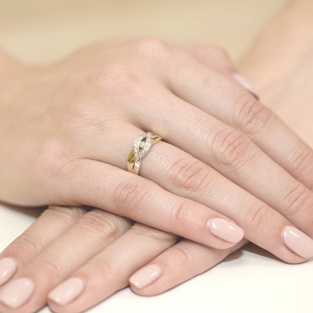 W0083.Z3.DIW.01_4 Pierścionek z diamentami i zielonymi kamieniami na dłoni z zadbanymi paznokciami.