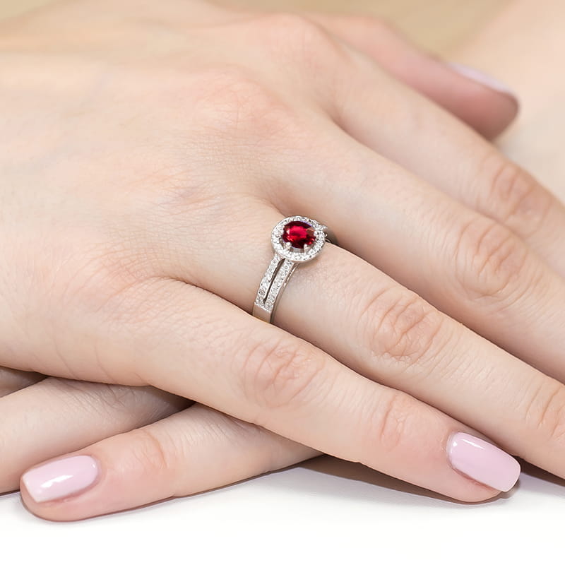 W0087.B3.RUR.01_4 Pierścionek z czerwonym kamieniem otoczonym diamentami na dłoni z delikatnym manicure.