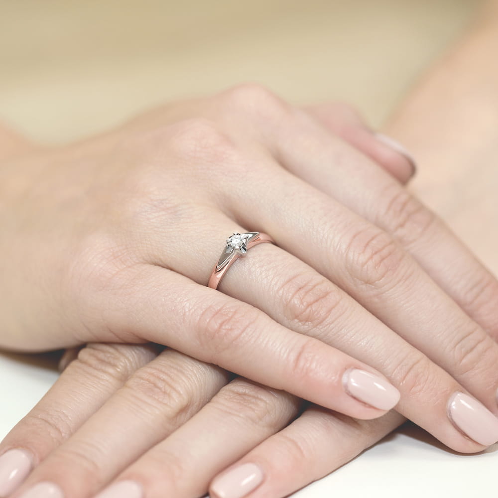W0088.R3.DIW.03_4 Pierścionek z diamentem na palcu, dłonie z delikatnym manicure w jasnym kolorze.