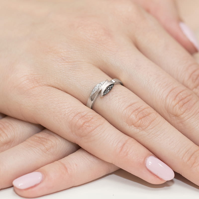 W0107.B3.DIB.01_4 Srebrny pierścionek z diamentami na palcu kobiecej ręki, z delikatnym manicure w jasnym kolorze.