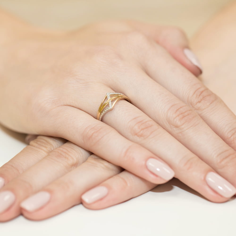 W0114.Z3.DIW.01_4 Złoty pierścionek z diamentami na palcu, dłonie z delikatnym manicure w jasnym kolorze.