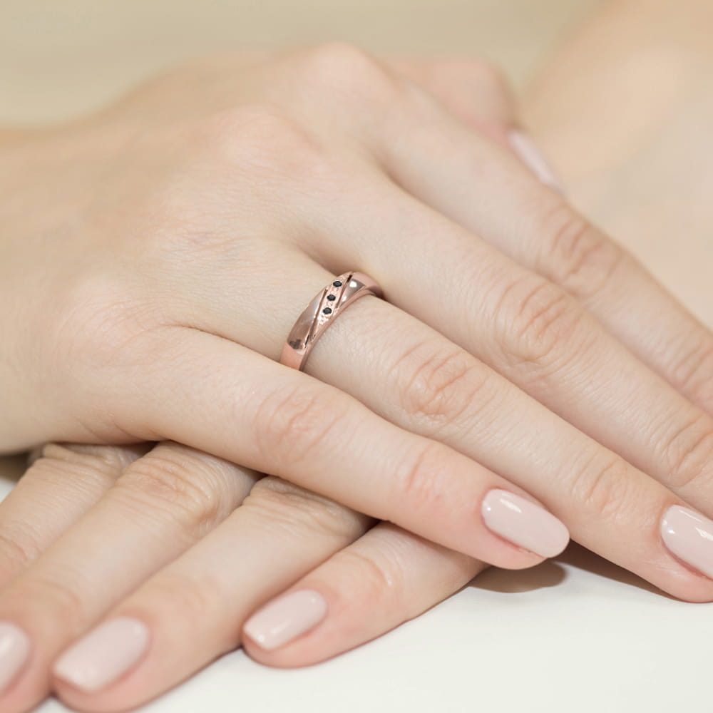 W0118.R3.DIB.01_4 Dwie ręce z delikatnym różowym pierścionkiem na palcu, paznokcie pomalowane na jasny kolor.