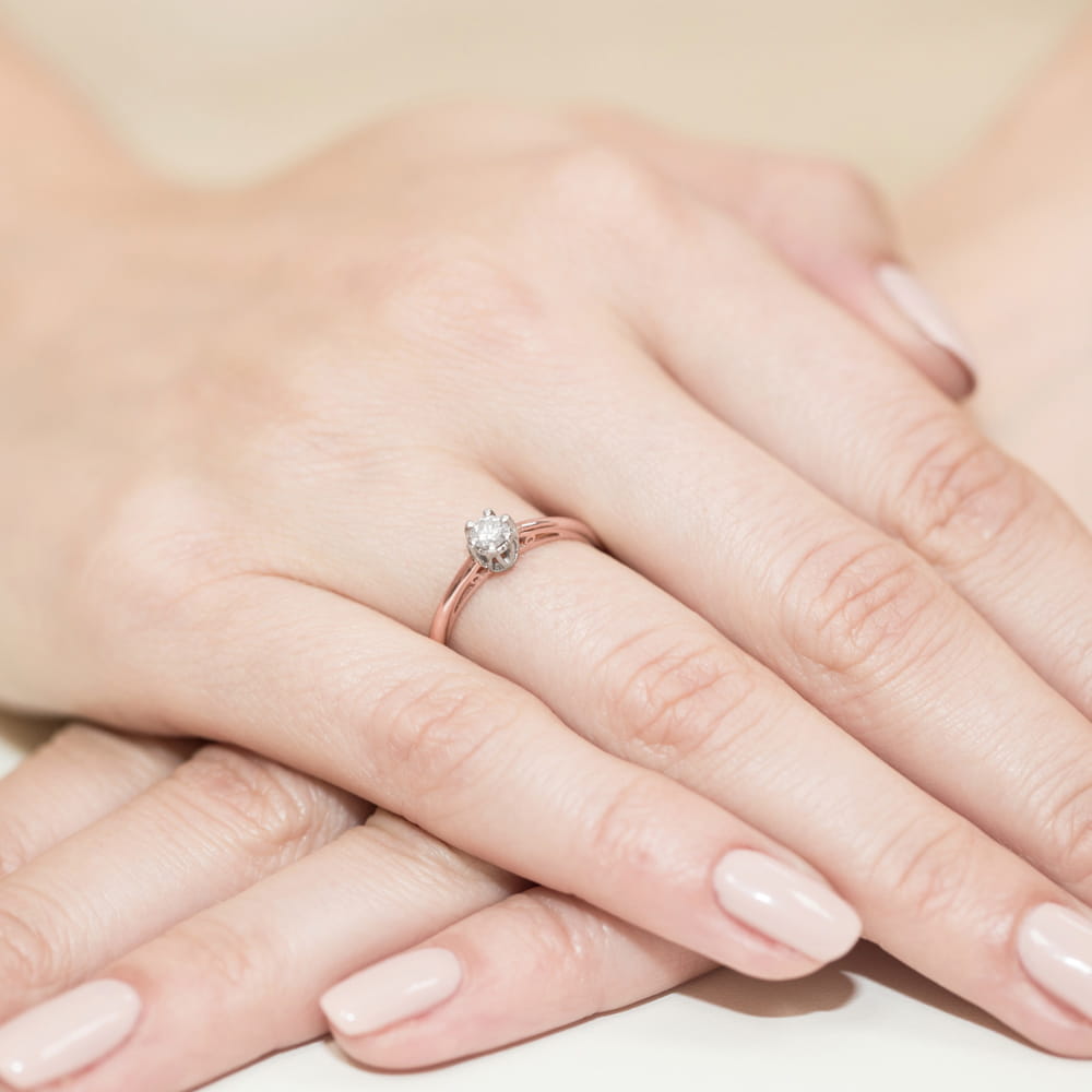 W0133.R3.DIW.01_4 Ręka z pierścionkiem zaręczynowym na palcu, delikatny kamień szlachetny w kształcie łzy, zadbane paznokcie.