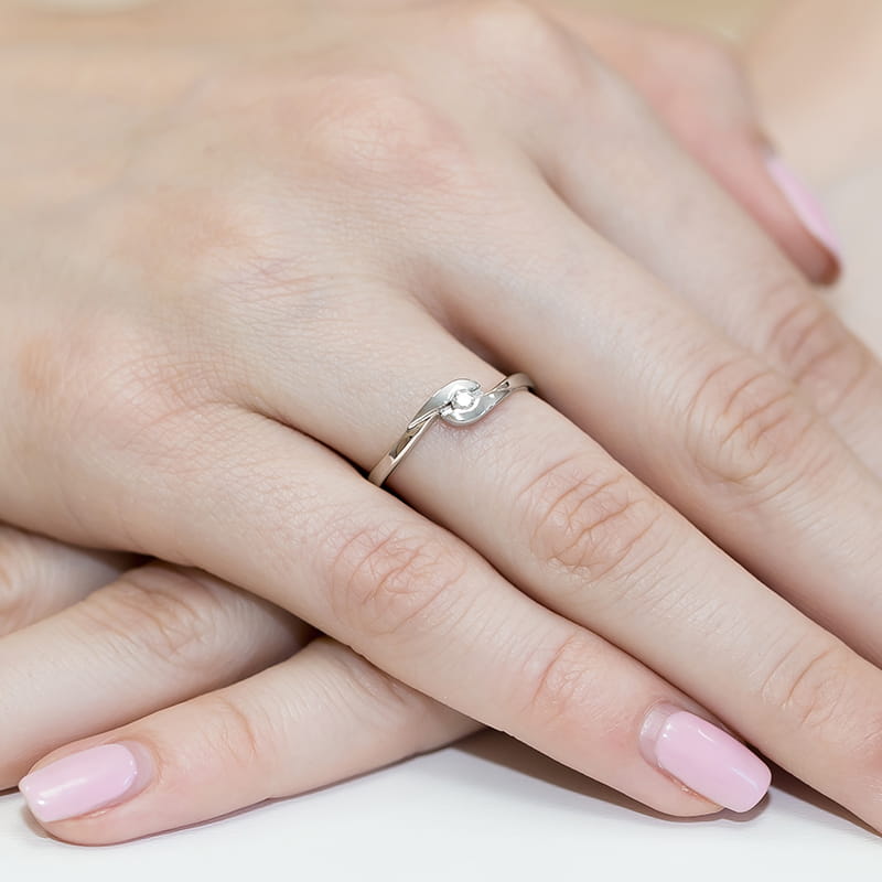 W0158.B3.DIW.01_4 Srebrny pierścionek z delikatnym wzorem na palcu z różowym manicure.