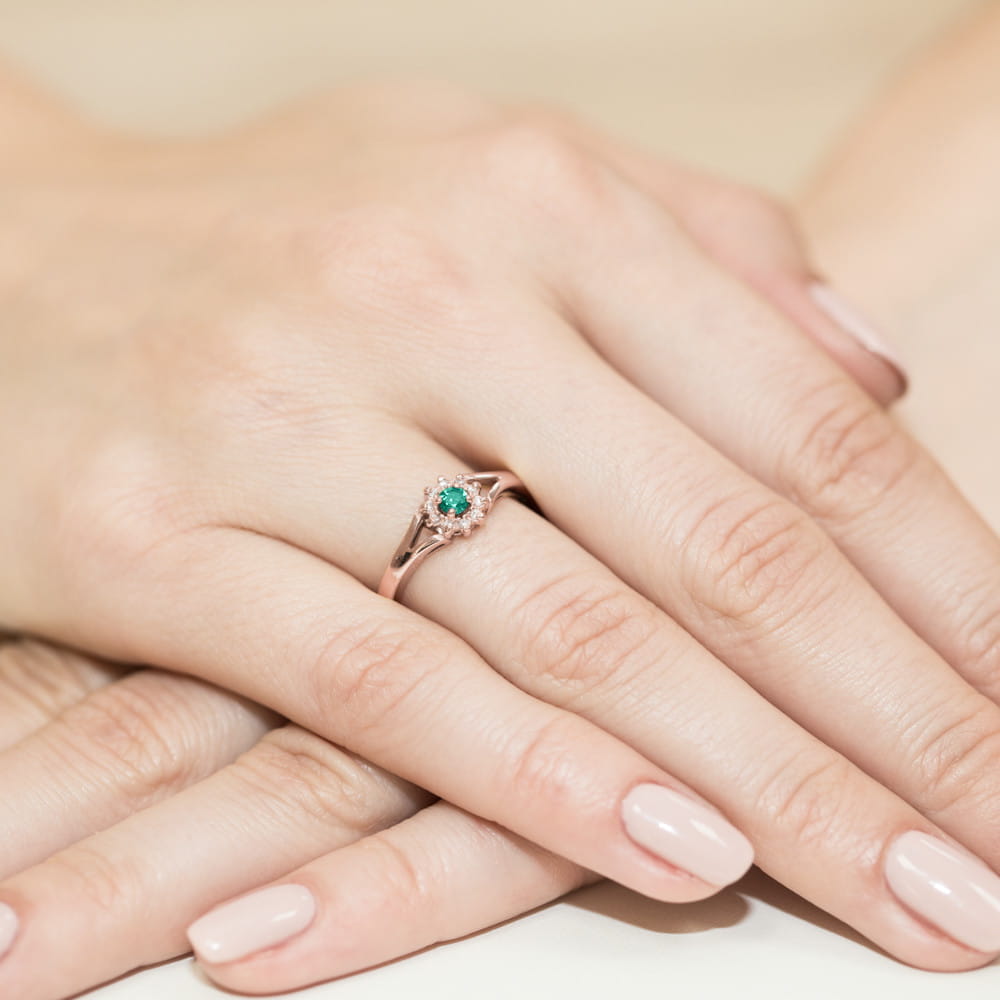 W0185.R3.EMG.01_4 Różowe złote pierścionek z zielonym kamieniem na palcu dłoni z zadbanymi paznokciami.