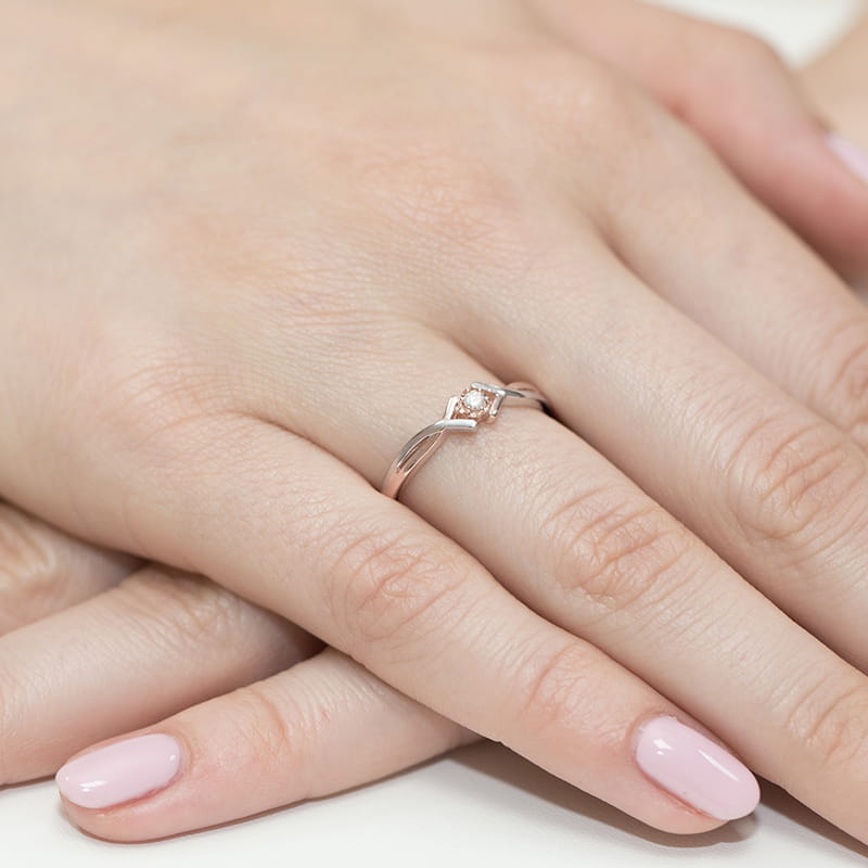W0190.R3.DIW.01_4 Srebrny pierścionek z różowym kamieniem na palcu z delikatnym manicure w jasnym kolorze.