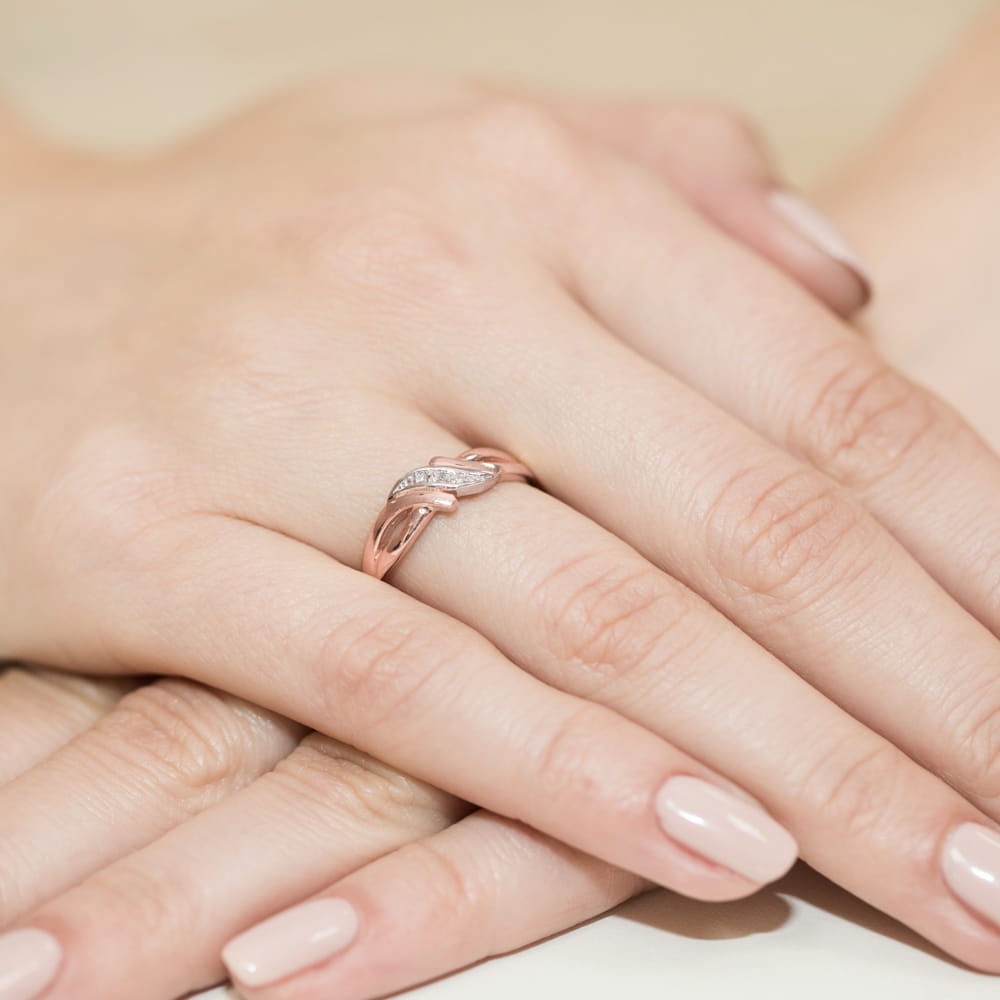 W0192.R3.DIW.01_4 Różowe złote pierścionek z diamentami na palcu dłoni z zadbanymi paznokciami.
