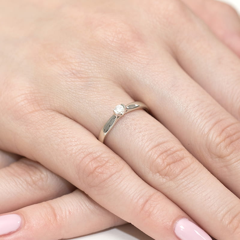 W0223.B3.DIW.01_4 Srebrny pierścionek z diamentem na palcu dłoni z różowym manicure.