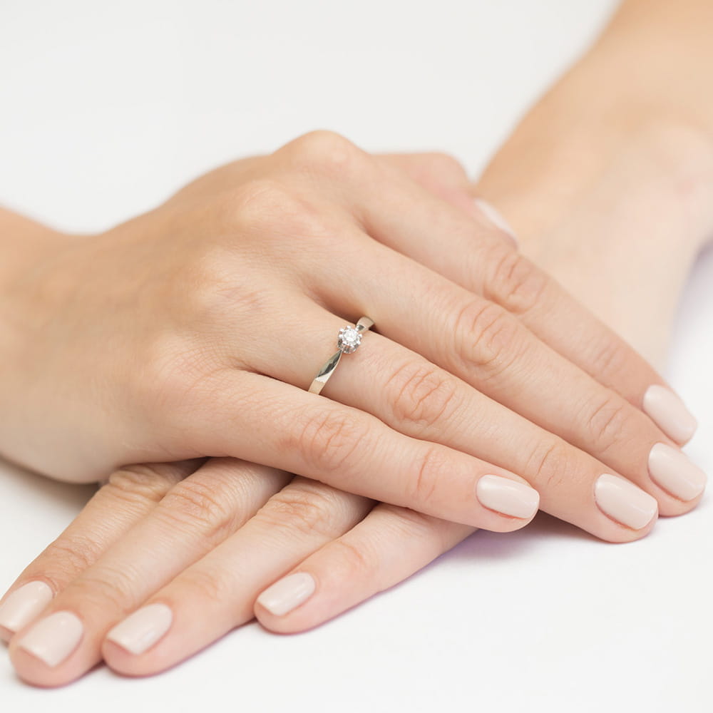 W0228.B3.LDW.03_4 Dwie dłonie z delikatnym pierścionkiem na palcu, paznokcie w jasnym kolorze.