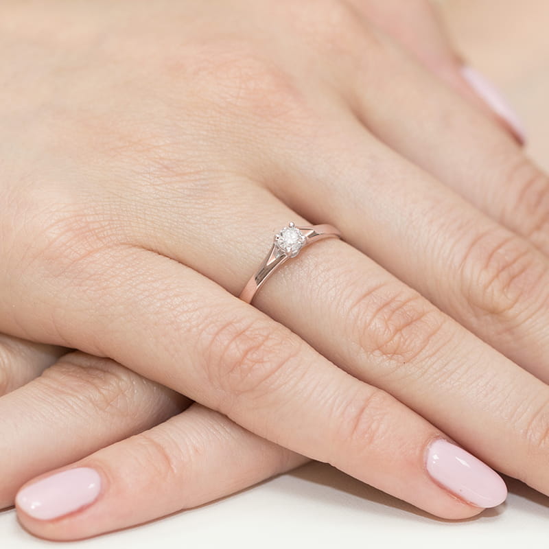 W0240.R3.LDW.01_4 Różowe złote pierścionek z diamentem na palcu kobiecej ręki z delikatnym manicure.