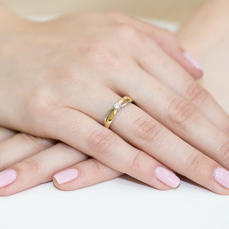 W0248.Z3.LDW.01_4 Złoty pierścionek z diamentem na palcu kobiety z różowym manicure.