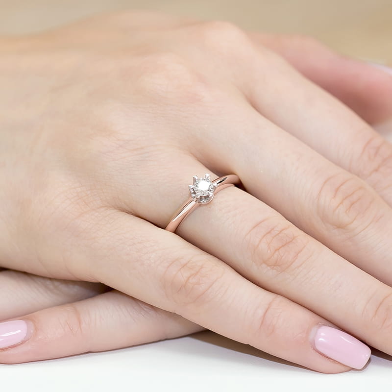 W0267.R3.DIW.02_4 Różowe złote pierścionek z diamentem na palcu kobiecej ręki z zadbanymi paznokciami.