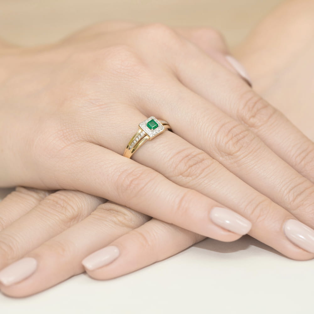 W0271.Z3.EMG.01_4 Złoty pierścionek z zielonym kamieniem szlachetnym, na dłoniach z delikatnym manicure.