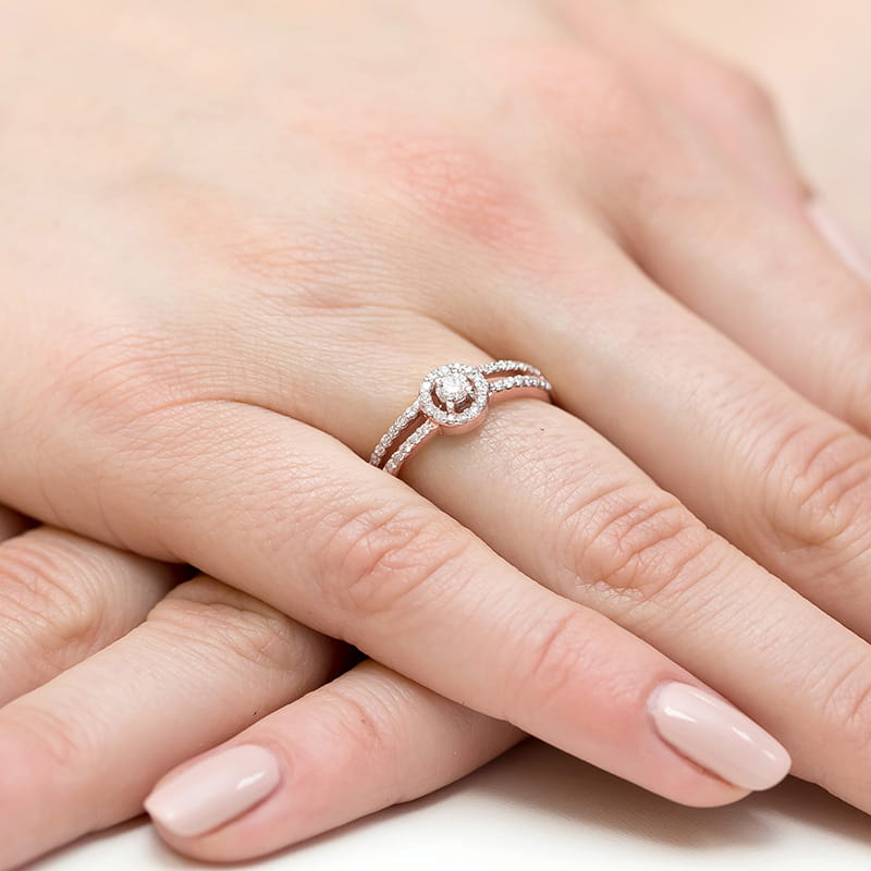 W0272.R3.DIW.01_4 Pierścionek z diamentem na palcu, z delikatnymi zdobieniami i jasnym manicure.