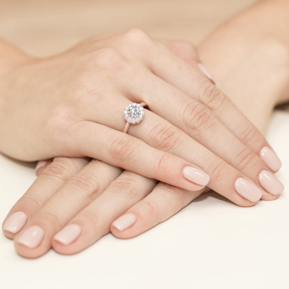 W0284.R3.SAW.01_4 Dwie ręce z delikatnym manicure, jedna z pierścionkiem z dużym, okrągłym diamentem.