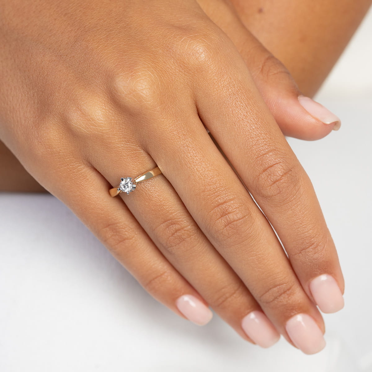 W0293.Z3.LDW.01_4 Złoty pierścionek z diamentem na palcu dłoni z zadbanymi paznokciami.