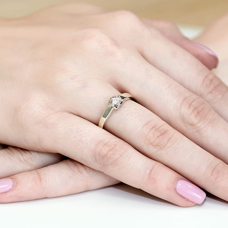 W0320.B3.LDW.03_4 Złoty pierścionek z diamentem na palcu kobiety z różowym manicure.