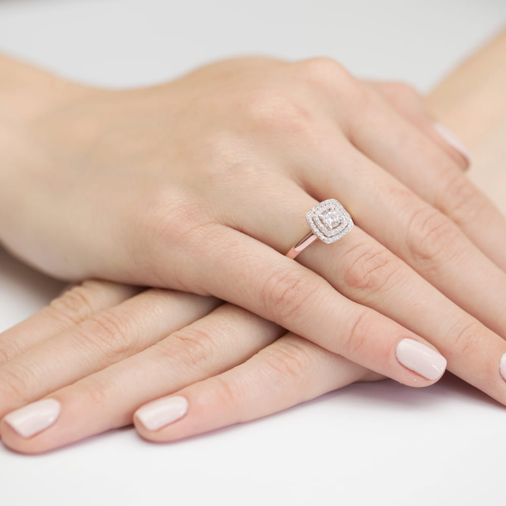 W0345.R3.DIW.01_4 Na dłoni z delikatnym manicure znajduje się pierścionek z diamentami w różowym złocie.