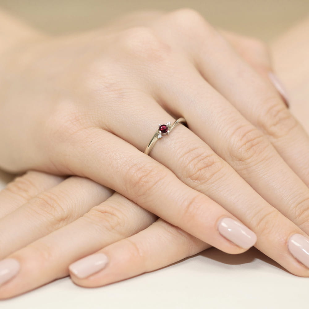 W0346.B3.RUR.02_4 Złoty pierścionek z rubinem i diamentem na palcu, dłonie z delikatnym manicure w jasnym kolorze.
