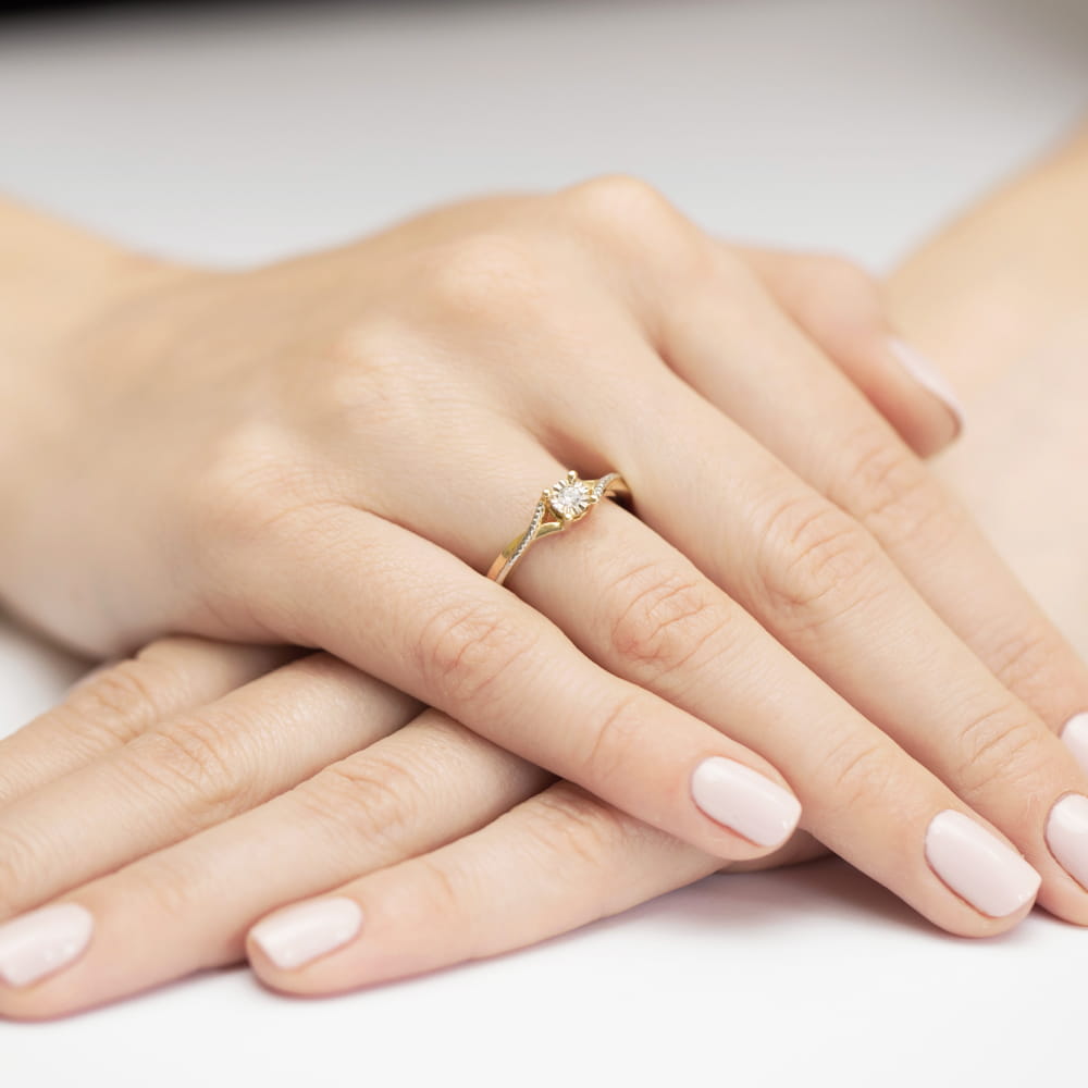 W0361.Z3.DIW.01_4 Złoty pierścionek z diamentem na dłoniach z delikatnym manicure.