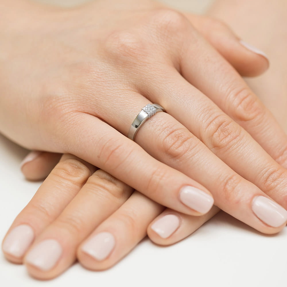 W0417.B3.DIW.01_4 Dwie dłonie z delikatnym manicure, jedna z pierścionkiem na palcu.