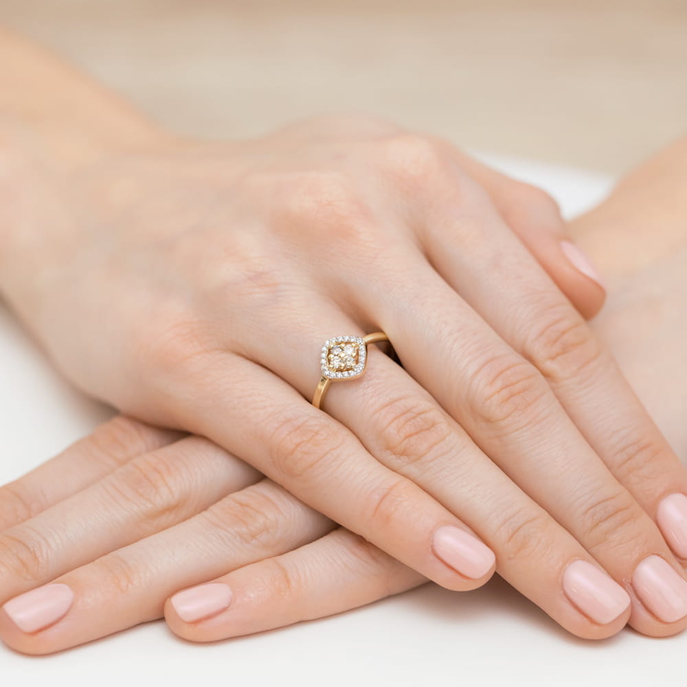 W0441.Z3.XXX.01_4 Złoty pierścionek z diamentowym zdobieniem na palcu kobiety, ręce z delikatnym manicure.