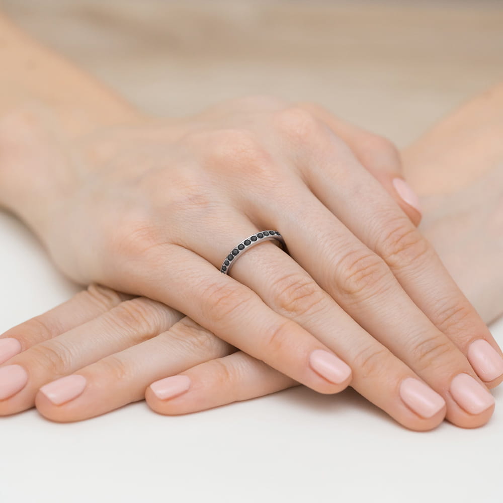 W0446.B3.DIB.01_4 Dwie ręce z delikatnym pierścionkiem na palcu, z zadbanymi paznokciami w jasnym kolorze.