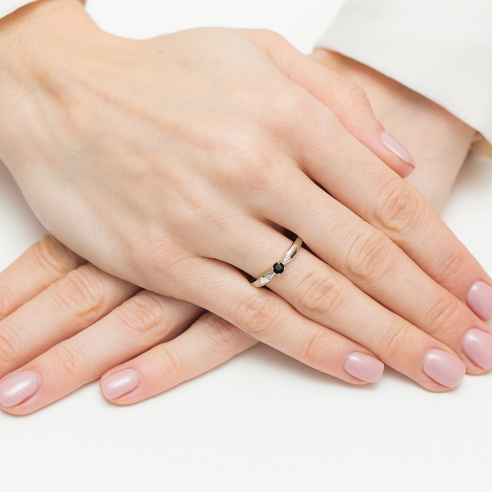 W0469.B3.DIB.01_4 Dwie dłonie z delikatnym pierścionkiem na palcu, z różowym manicure.