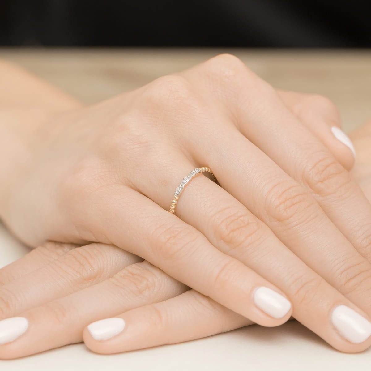 W0479.Z3.DIW.01_4 Złoty pierścionek z diamentami na palcu, dłonie z zadbanymi paznokciami w jasnym kolorze.