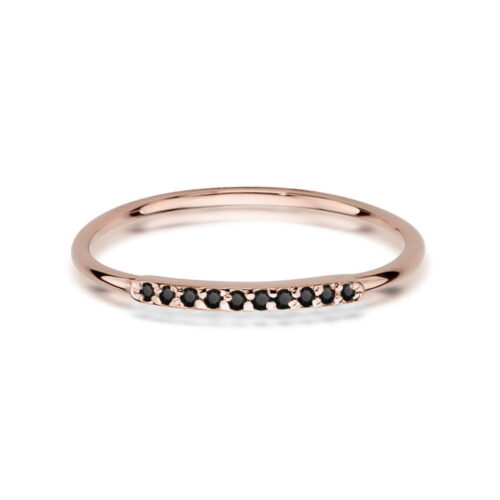 Różowe złote pierścionek z czarnymi kamieniami wzdłuż delikatnej obrączki.