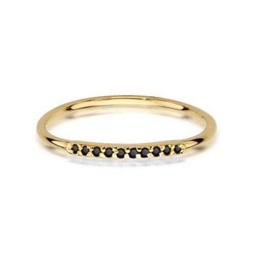 Złoty pierścionek z czarnymi kamieniami wzdłuż delikatnej obrączki.