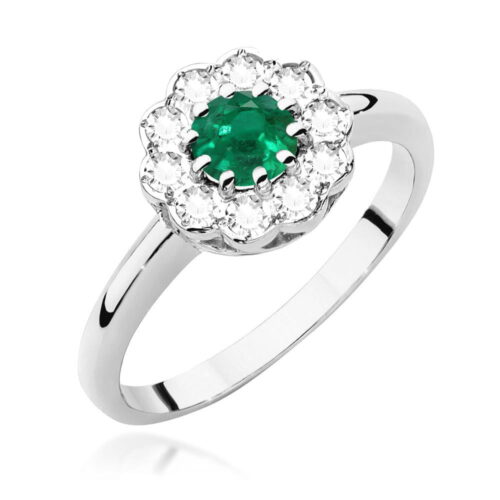 Srebrny pierścionek z zielonym szmaragdem otoczonym przez błyszczące, przezroczyste kamienie.