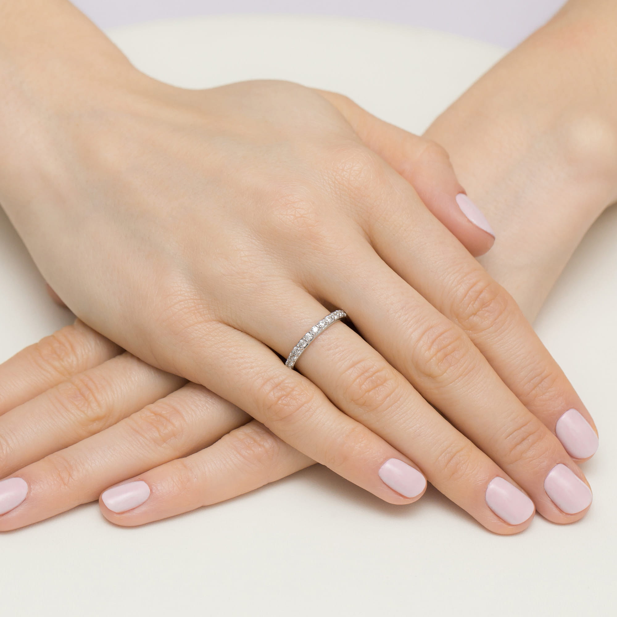 W0532.B3.DIW.01_4 Dwie ręce z delikatnym manicure, na jednej z nich pierścionek z diamentami.