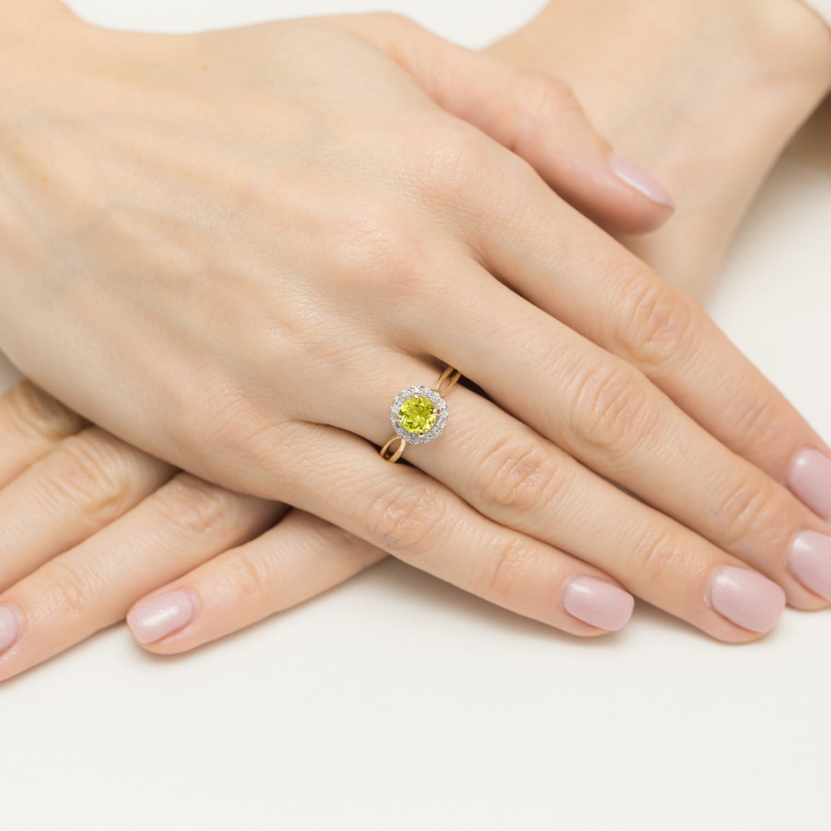 W0538.Z3.PEG.01_4 Złoty pierścionek z żółtym kamieniem na palcu, dłonie z delikatnym manicure w jasnym kolorze.
