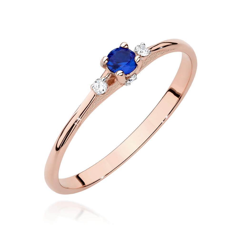W0614.R3.SAB.01_1 Różowe złote pierścionek z niebieskim kamieniem i trzema małymi diamentami po bokach.
